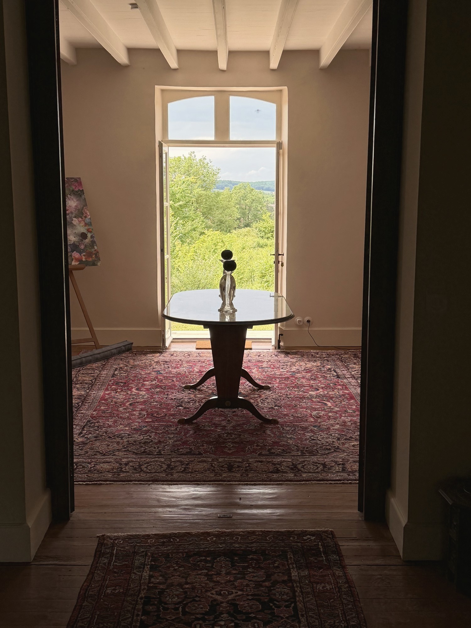 Blickachse im Manoir Comté mit antikem Teppich, Tisch und Kunst