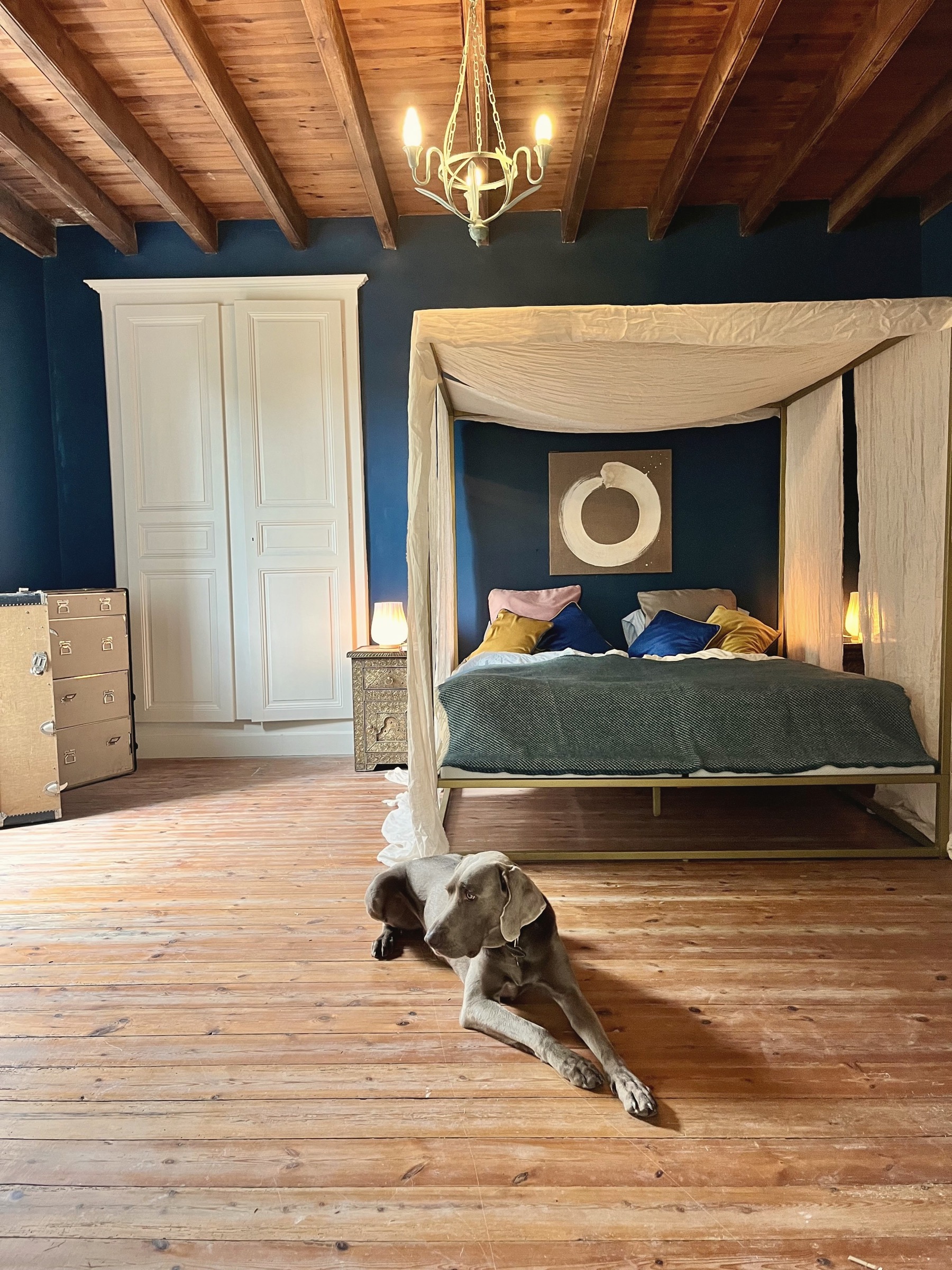Bedroom beneath timber beams at Manoir Comté