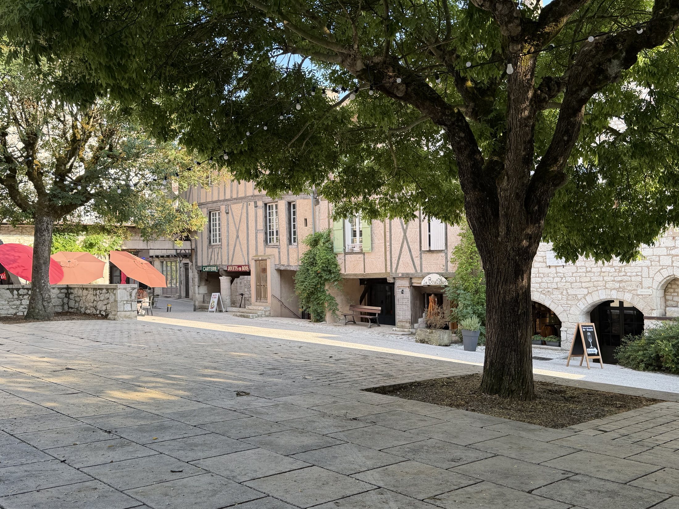 Der stille Platz der Bastide Monflanquin unter alten Bäumen